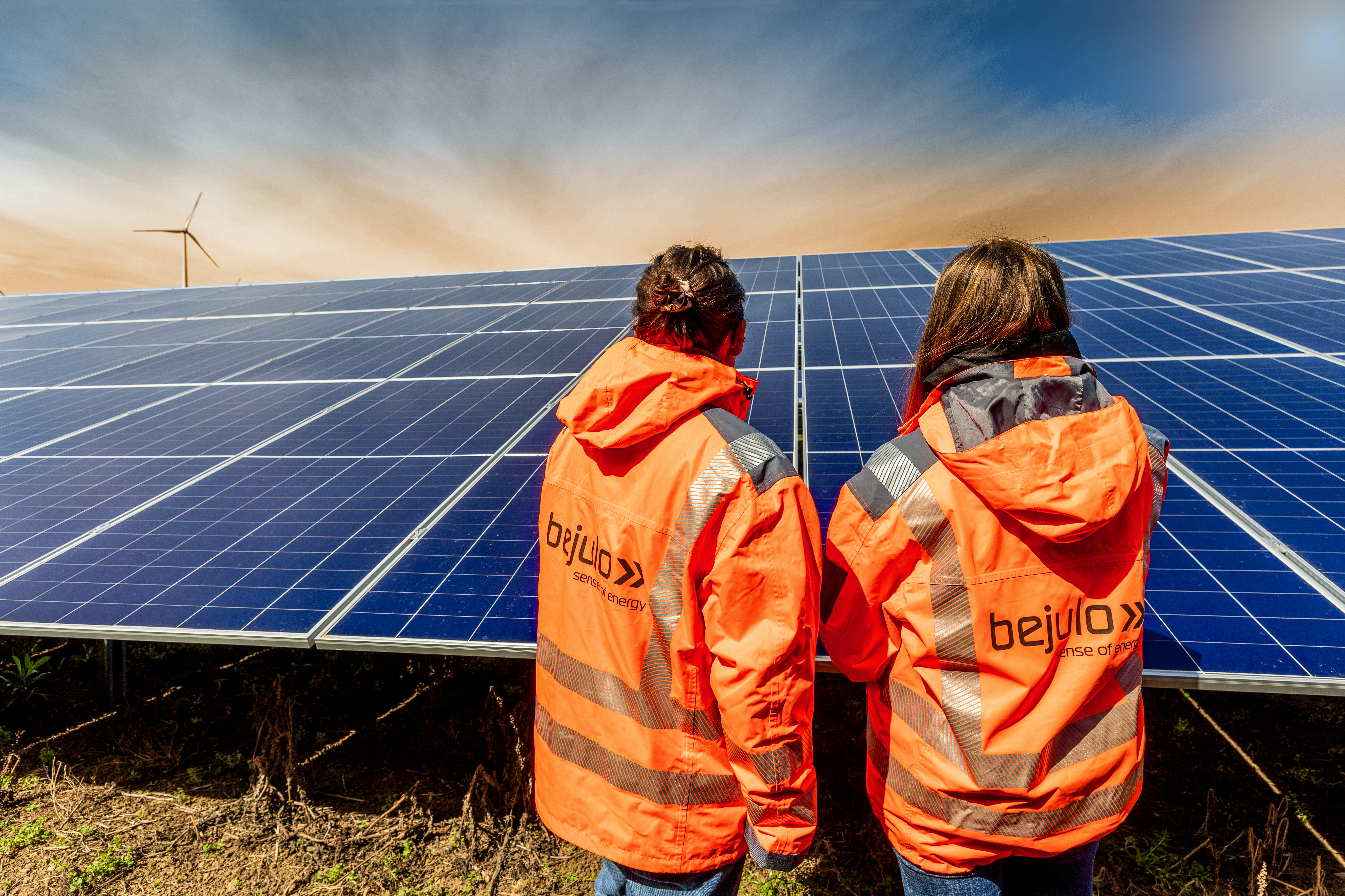 Two bejulo employees in branded workwear inspecting solar modules